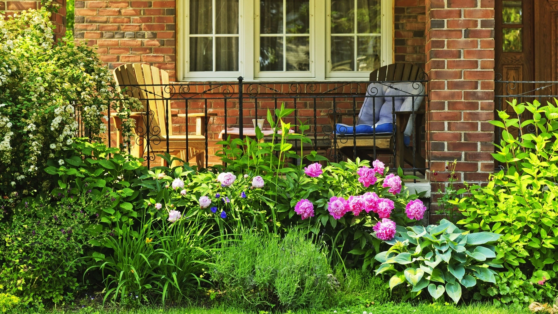 A brick home in Harlem, NY with vibrant landscaping. 