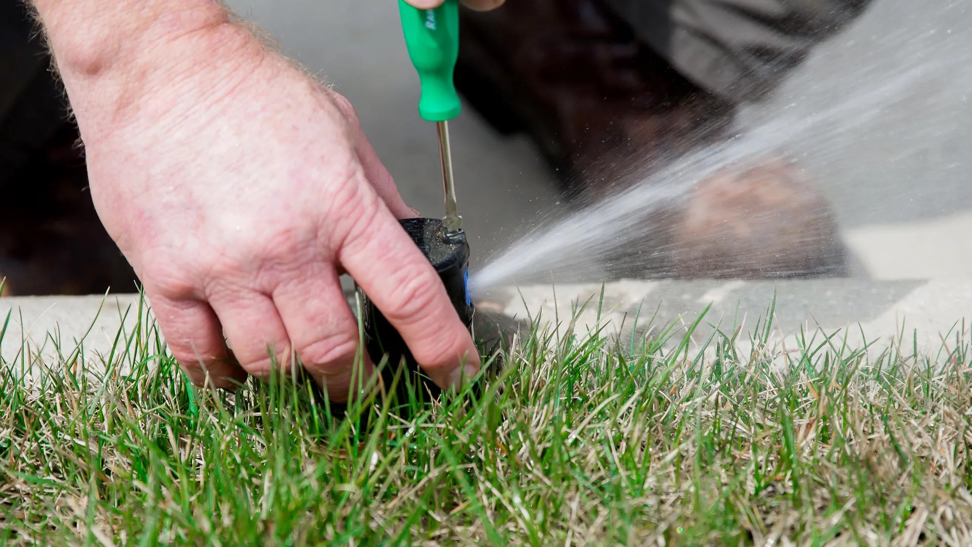 A technician maintaining a sprinkler head in The Bronx, NY.