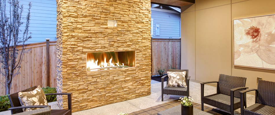 A custom, stone, gas-burning, outdoor fireplace constructed by our team for a client in Danbury, CT.
