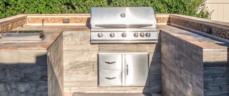 A custom built outdoor kitchen in Woodcliff Lake, NJ with a grill, storage, and cooler.